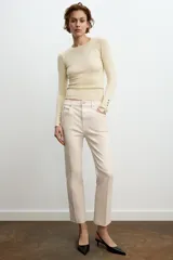 Jeans de mezclilla azul claro, tiro medio, corte recto y ligeramente acampanado en el bajo. Presenta cinco bolsillos y cierre frontal con cremallera y botón metálico.