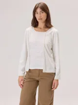 Remera de manga larga color blanco con panel central de lino y detalles de vivos en contraste. Presenta un diseño de cuello redondo y corte recto.