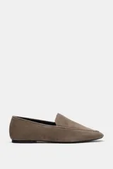 Mocasín plano de serraje color marrón, con diseño de copete subido, pespuntes decorativos en el cuerpo y punta ligeramente perfilada.