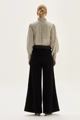 Blusa de algodón con estampado de rayas verticales en tonos crudo y negro. Presenta cuello mao con lazo para atar, bordados florales en negro y beige en la zona del pecho y hombros, y mangas largas con puños fruncidos elásticos.