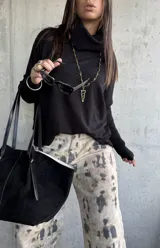 Sweater negro de punto con cuello polera, mangas largas con puños ajustados y diseño holgado.