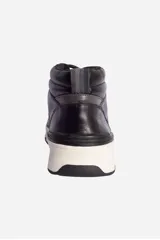 Bota de cuero marrón con cordones, caña media y suela de goma color beige.