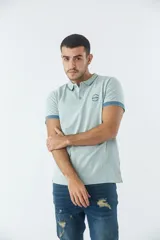 Remera cuello polo de manga corta con diseño a rayas horizontales finas. Presenta logo estampado en el pecho, cierre frontal con botones y terminaciones en color contrastante en las mangas.