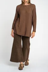 Sweater de tejido de punto acanalado en color marrón, con cuello redondo, mangas largas y aberturas laterales en el ruedo.