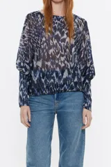 Jersey de lúrex con estampado abstracto en tonos azules y grises. Modelo con escote redondo y manga murciélago larga con puño ajustado.