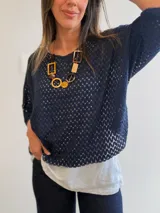 Buzo azul marino con diseño calado de manga corta y corte oversize, acompañado por una musculosa blanca básica interior.