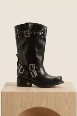 Bota de cuero negro de caña media, con múltiples correas con hebillas metálicas, tachas decorativas y taco bajo cuadrado.