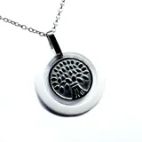 Collar con cadena de acero plateado y dije redondo con reborde de cerámica blanca satinada y diseño de árbol de la vida en acero.