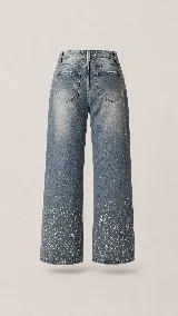 Jean de corte wide leg y tiro medio, confeccionado en denim con efecto lavado. Presenta un diseño con destellos brillantes distribuidos por toda la prenda, con mayor intensidad hacia el ruedo.