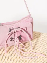 Cartera mini tipo baguette color gris con efecto gastado, confeccionada en cuero ovino. Tiene correa corta de hombro, cierre metálico, bolsillo interno y dos bolsillos frontales con apliques metálicos níquel.