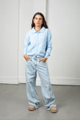 Saco tejido de punto color blanco, con cuello tipo polo, cierre frontal con botones y diseño con flores bordadas en relieve.