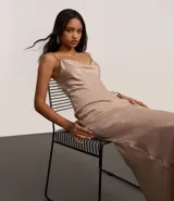 Vestido midi color beige confeccionado en satén texturizado, con breteles finos y escote drapeado.