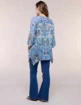 Blusa holgada de poliéster con estampado de arabescos en tonos azules, escote en V con botones frontales, mangas 3/4 y ruedo asimétrico en punta.