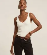 Blusa sin mangas de punto acanalado color crema, con escote en V y espalda descubierta. Confeccionada en una mezcla de viscosa y poliamida, presenta un ajuste al cuerpo y textura vertical en relieve.