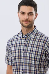 Camisa sport de manga corta con estampa a cuadros en tonos azules, blancos, grises y amarillos, cuello con botones y cierre frontal abotonado.