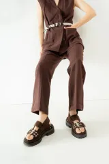 Sandalias negras de cuero con plataforma y hebillas metálicas.