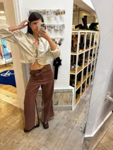Pantalon sastrero de lino color marrón con paneles laterales en contraste beige, diseño de tiro alto y corte recto. Presenta un bordado de caballo en el bolsillo frontal.