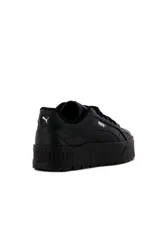 Championes de plataforma Puma modelo Karmen II Idol, con diseño en blanco, negro y franja lateral celeste.