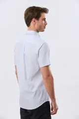 Camisa de manga corta a rayas celestes y blancas, con cuello abotonado, bolsillo frontal en el pecho con logo bordado y cierre frontal de botones.