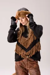 Sweater de punto color negro con cuello medio alto y silueta relajada. Presenta un diseño distintivo con líneas en forma de V decoradas con flecos color marrón aplicados a mano.