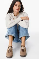 Zuecos de cuero negro con diseño tipo sneaker, cordones y suela de goma color caramelo. Presentan detalle de marca Petra en la lengüeta.