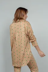 Camisa de manga larga color rosado con estampado de flores anaranjadas y blancas.