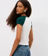 Remera de algodón con diseño tipo ringer, de corte ajustado y mangas cortas con sisa raglán en color verde oscuro. Presenta estampa frontal con lettering Montreal y detalles en color blanco.