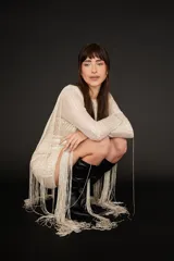 Minivestido color champagne con lentejuelas y flecos largos.