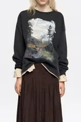 Sudadera de corte recto y holgado, con cuello redondo y manga larga. Presenta un estampado artístico de paisaje montañoso con un ciervo en el frente.