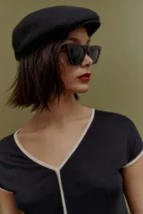 Blusa negra de tejido de punto, con escote en V y mangas cortas con ribete en color crema.
