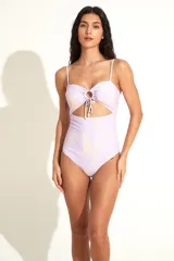 Traje de baño enterizo tipo trikini color lila con estampado floral amarillo. Presenta escote recto con breteles finos, abertura en el abdomen y detalle de frunce con argolla en el busto.