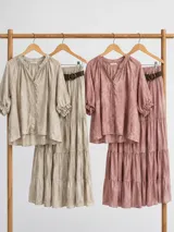 Falda larga de estilo campesino, color beige con sutil estampado, de diseño amplio con volantes y cintura elastizada.