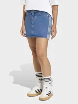 Falda mini de denim azul con diseño clásico de cinco bolsillos y cierre frontal con botones. Presenta las icónicas tres tiras de la marca en los laterales.