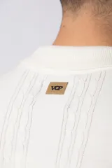 Camisa de punto de manga corta con cuello tipo bowling y cierre frontal de botones. Presenta un diseño texturizado con franjas verticales y detalles de contraste en blanco en los bordes de las mangas.