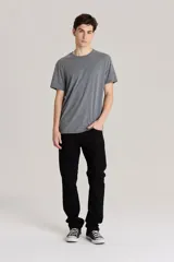 Jean de corte slim fit en color negro, confeccionado en denim rígido. Presenta cierre de botón y cremallera, con diseño clásico de cinco bolsillos y tiro medio.