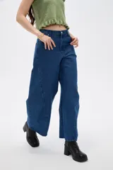 Pantalon de jean azul de corte amplio y tiro bajo, con costuras laterales curvas que le dan una silueta redondeada.