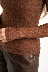 Remera de encaje color marrón, de corte ajustado al cuerpo y manga larga, con cuello redondo.