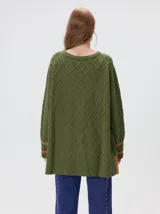 Sweater de cuello redondo con diseño de tejido en relieve de rombos, manga larga y calce holgado. Presenta logo bordado en el pecho y aberturas laterales en el ruedo.