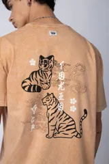 Remera de corte semi-oversize en color naranja con efecto de lavado tipo snow. Presenta un pequeño estampado gráfico en el pecho y cuello redondo.