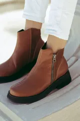 Bota corta de cuero negro con diseño minimalista, cierre lateral metálico y taco bajo cuadrado de 4 cm.