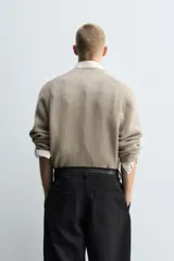 Jersey de punto con diseño boxy fit, cuello redondo y manga larga. Presenta una textura acanalada y acabados en rib en puños y ruedo.