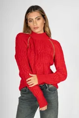 Sweater rojo de punto trenzado con cuello alto y detalle de cadena dorada en los hombros.