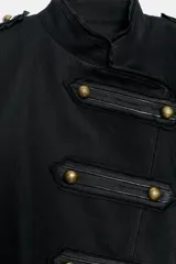 Chaqueta de estilo militar en color negro, con cuello redondo y cierre frontal mediante alamares decorativos. Presenta mangas largas con botones en los puños y forro interior a tono.