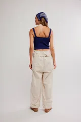 Enterito de inspiración laboral confeccionado en tejido de algodón ligero, color blanco, con top tipo halter, botones laterales y piernas holgadas.