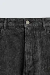 Pantalón de corte baggy fit confeccionado en tejido de algodón con textura y efecto lavado. Presenta diseño de cinco bolsillos, cierre frontal con cremallera y botón.