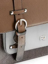 Cartera tipo maletín con diseño tricolor en tonos marrón, beige y chocolate. Presenta solapa frontal con correas decorativas, hebillas metálicas doradas, asa superior y correa ajustable para hombro.