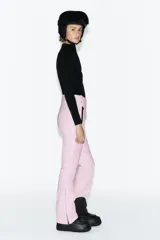 Pantalón de esquí rosa con corte flare, tiro alto, bolsillos frontales con cremallera y bajos con cremallera y aplicación de parche técnico.