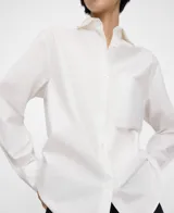 Camisa de algodón color blanco, con cuello camisero, manga larga con puño abotonado, cierre frontal con botones y un bolsillo aplicado en el pecho.