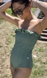 Malla enteriza strapless color verde, con textura acanalada y detalle de volados en el escote.