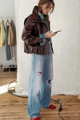 Chaqueta de efecto piel en color bordó, con cuello subido, manga larga con puños y bajo elástico. Presenta cierre frontal con cremallera y botones a presión ocultos, además de bolsillos laterales.